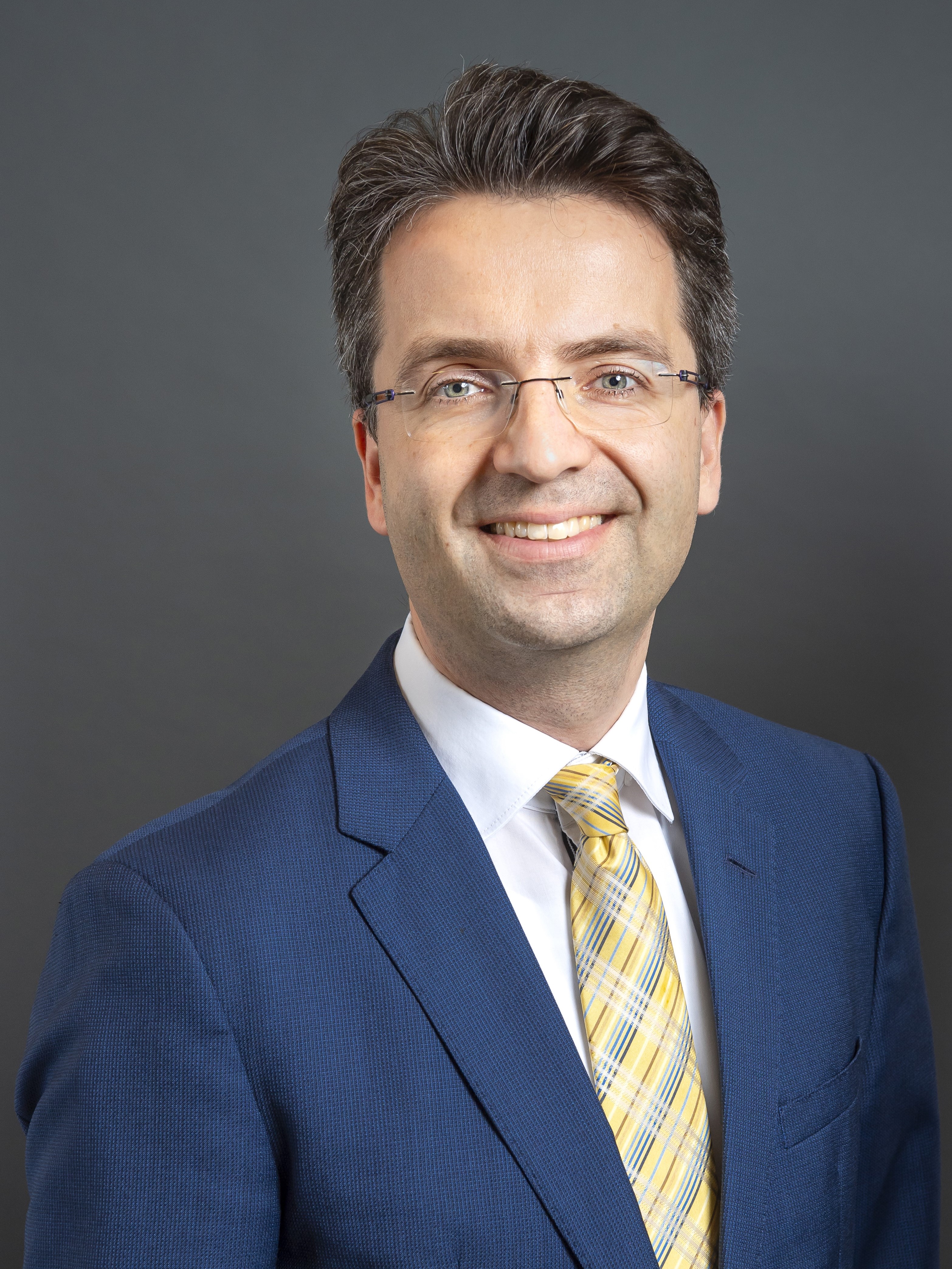 Portrait von Doktor Julian Böcker vor neutralem Hintergrund.