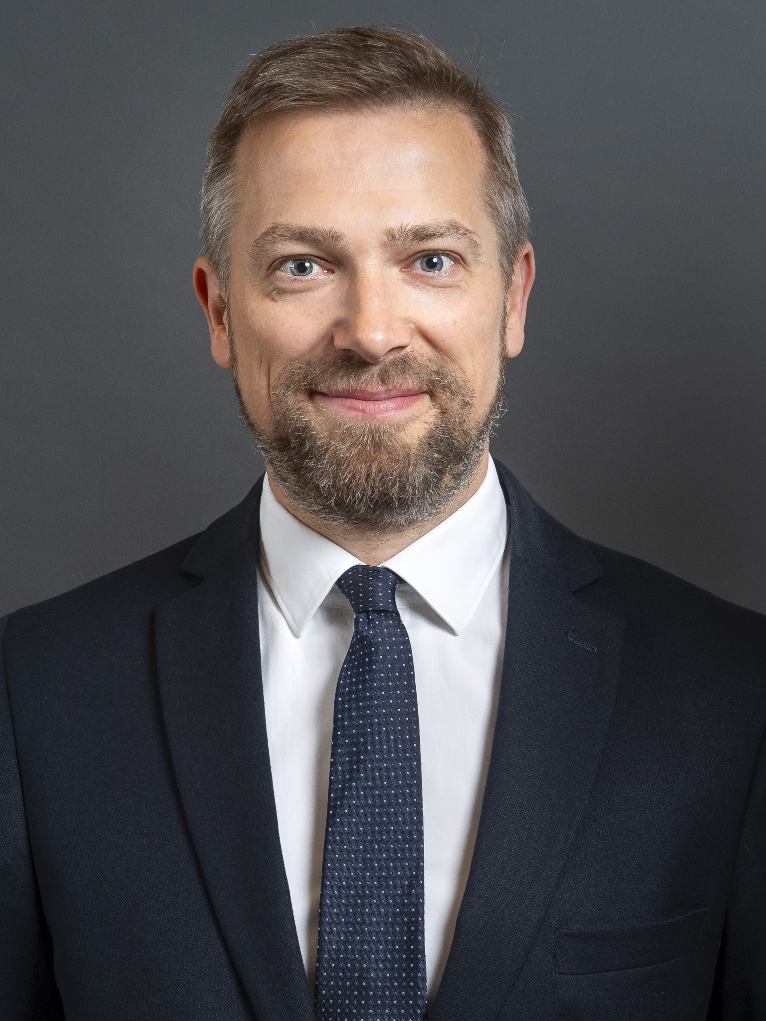 Portrait von David Volkert vor neutralem Hintergrund.