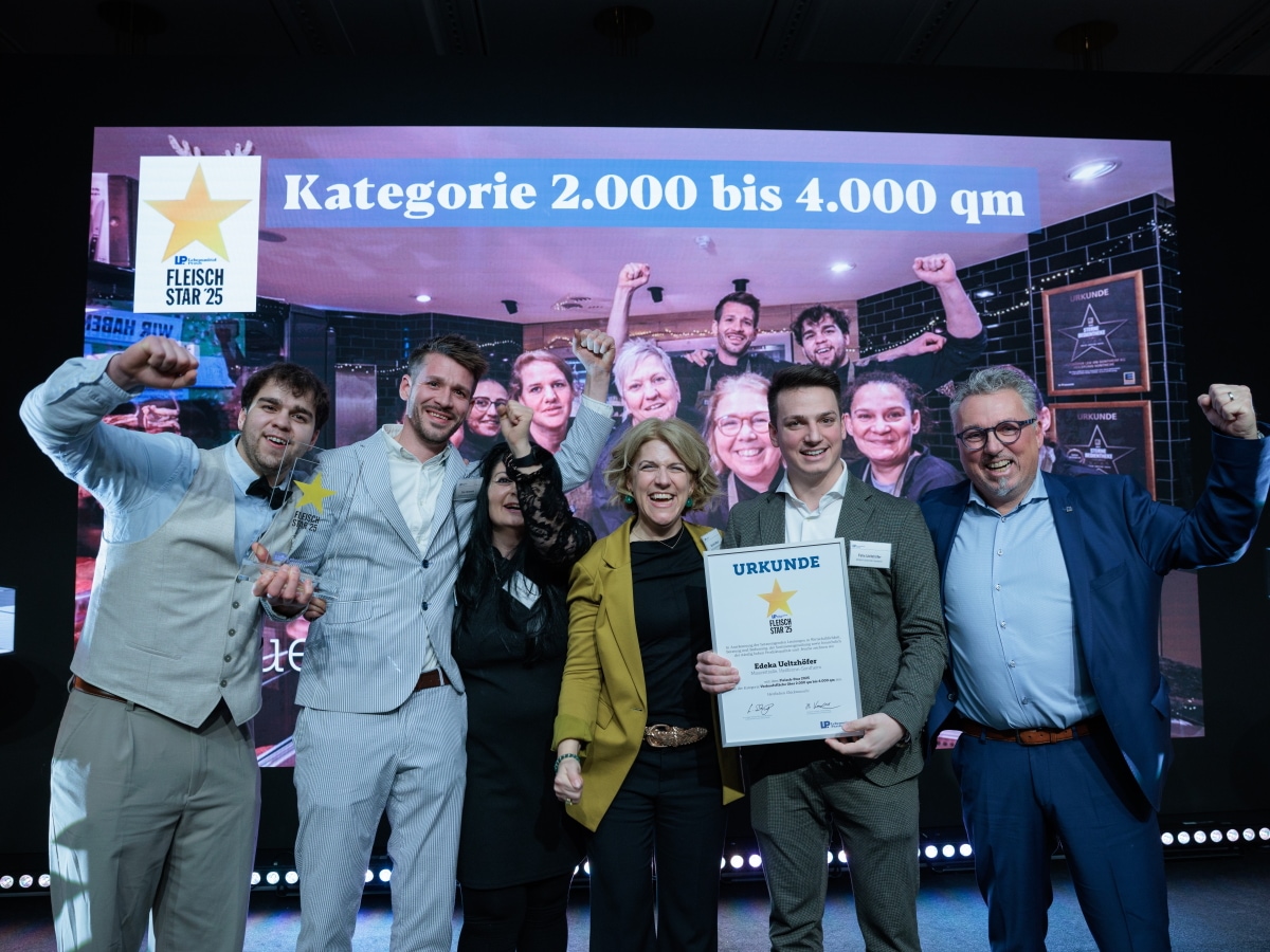 2 Frauen und 4 Männer stehen zusammen und jubeln, einer hält eine Urkunde, einer einen gläsernen Pokal mit Stern.