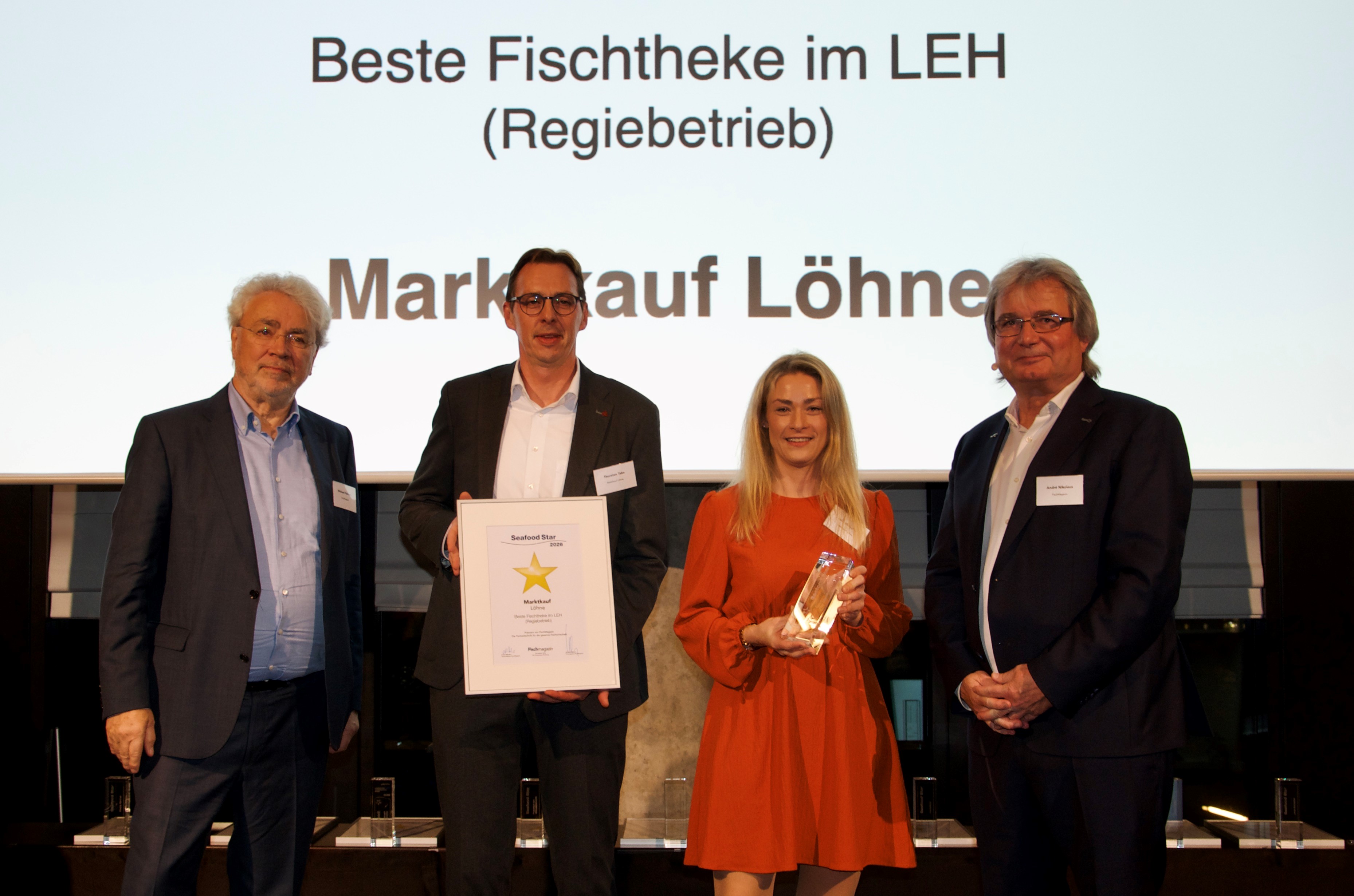 Marktleiter Thorsten Take und Julia Mutschler, Abteilungsleiterin für Fisch, nehmen die Trophäe und die Urkunde entgegen.