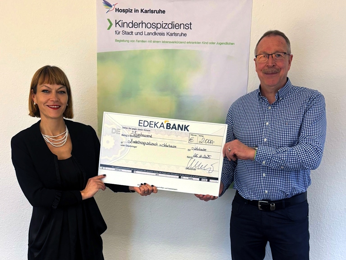 Eine Frau und ein Mann halten gemeinsam einen symbolischen Spendenscheck mit 2000 € für den Kinderhospizdienst Karlsruhe.