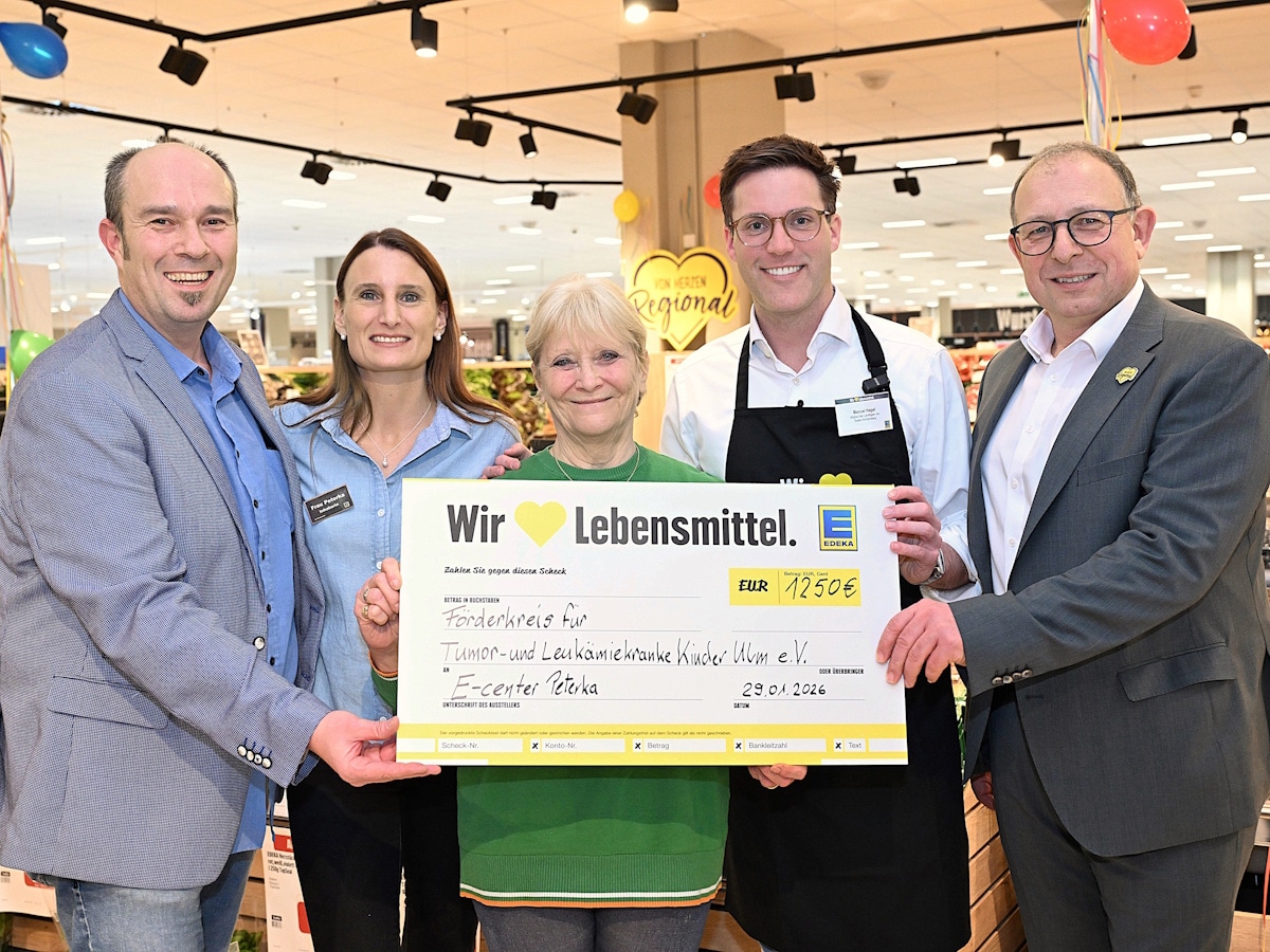 2 Frauen und 3 Männer stehen mit einem symbolischen Scheck in einem EDEKA-Markt.