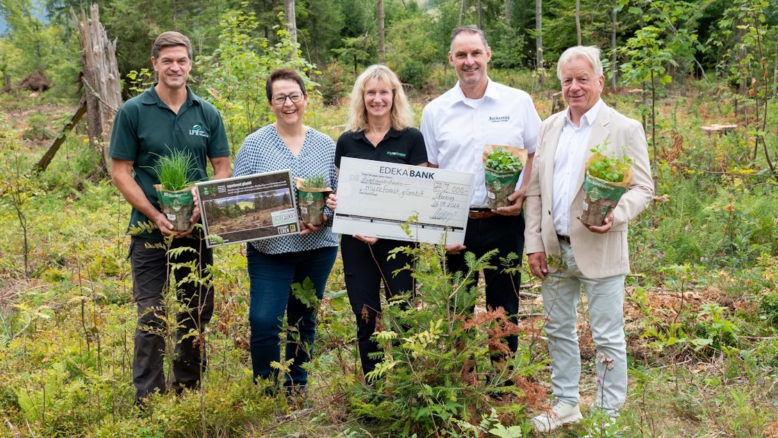 Fünf Personen im Wald mit Kräutertöpfen und Spendenscheck