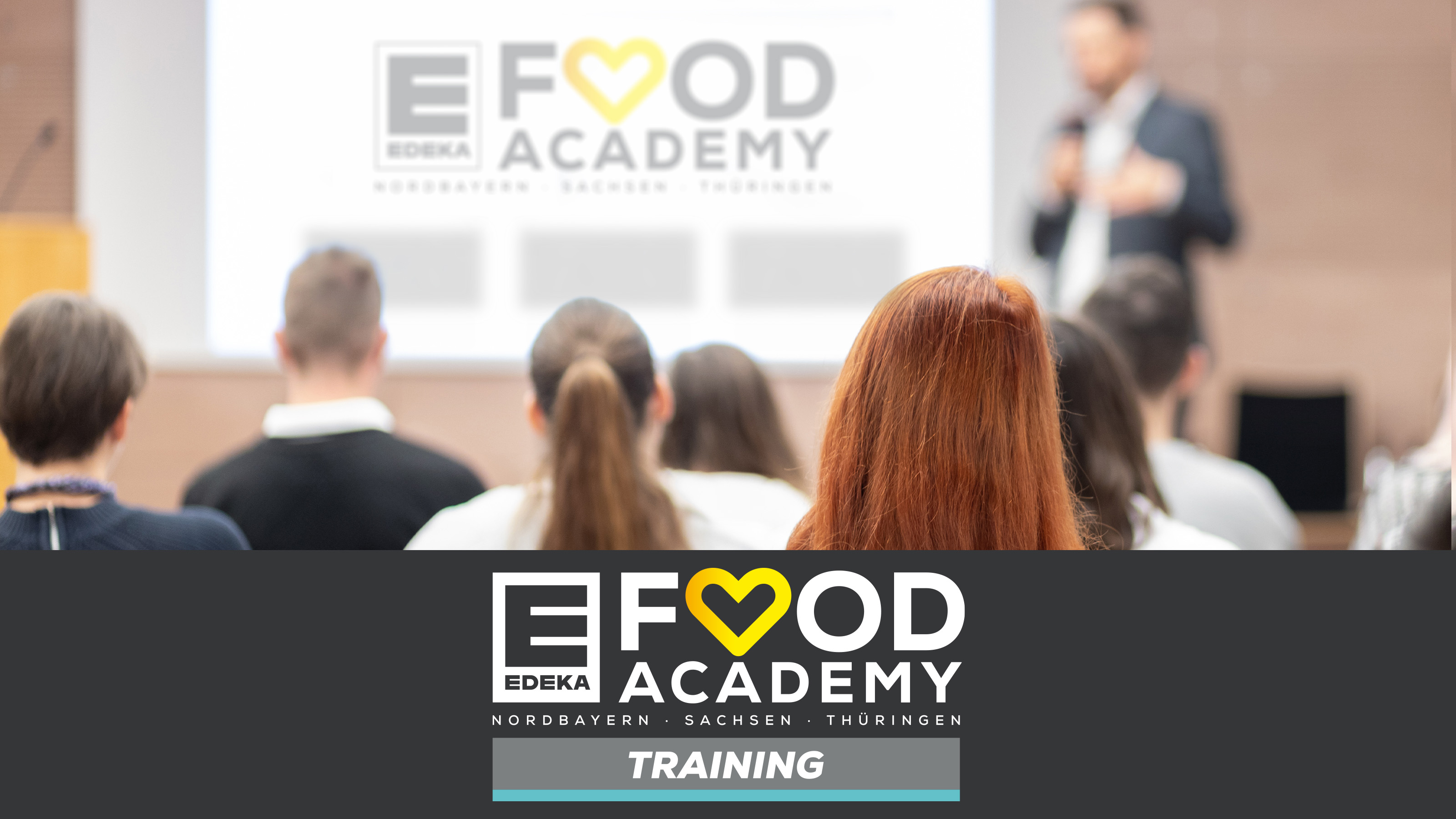 Mehrere Leute bei einem Vortrag  mit großer Leinwand für den Food Academy Bereich Training