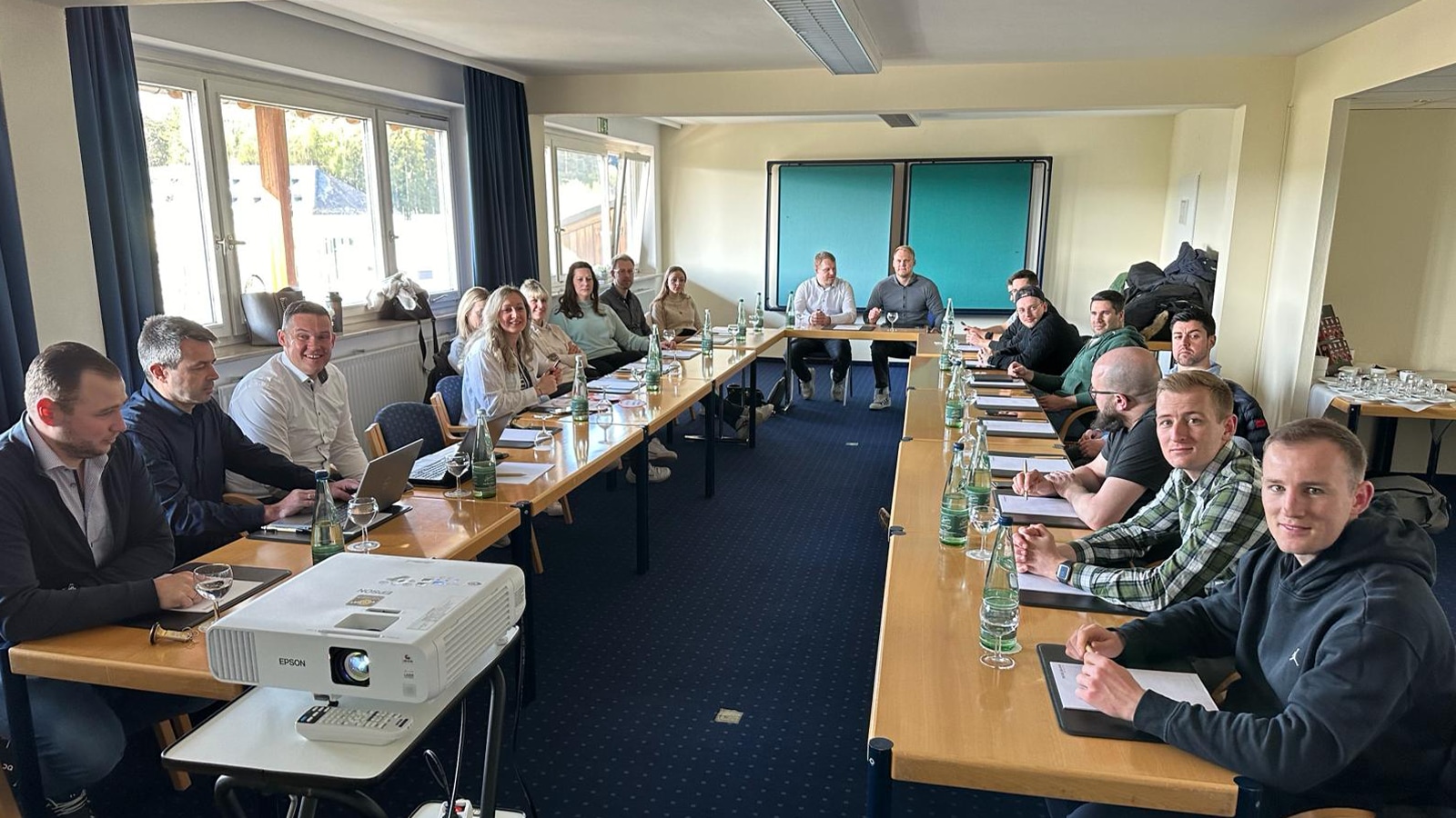 Gruppenfoto Jungkaufleute Seminar an Tischen sitzend