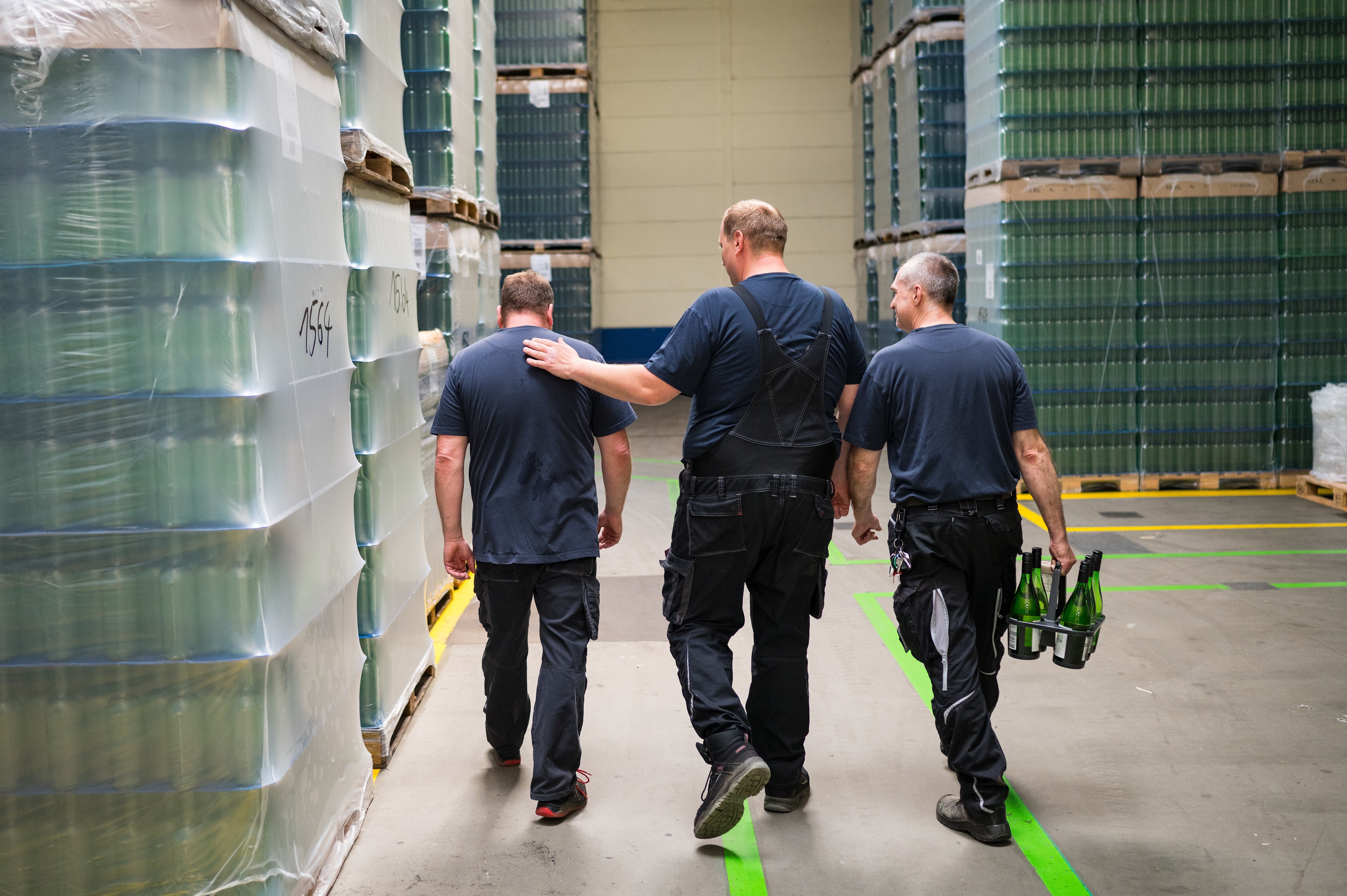 Dre Kollegen gemeinsam im Lager mit dem Rücken zur Kamera