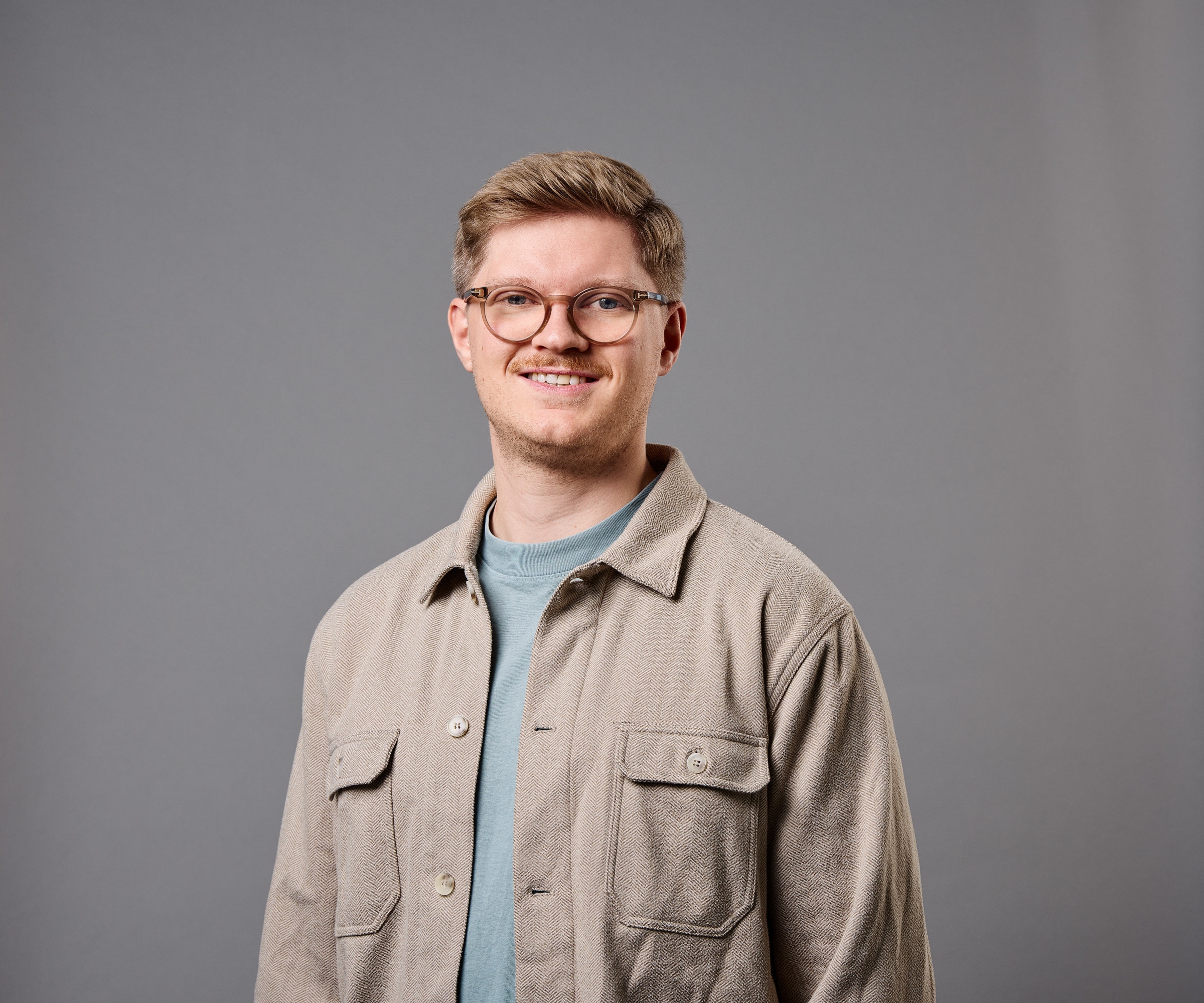 Lucas Saaler im Portrait vor grauem HIntergrund 