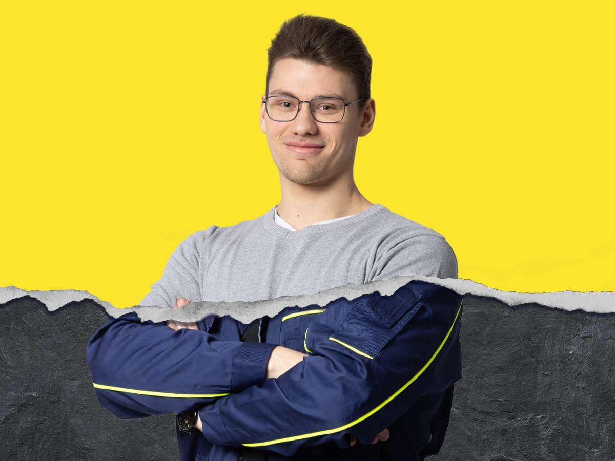 Azubi aus der Logistik vor gelben Hintergrund mit Risskante