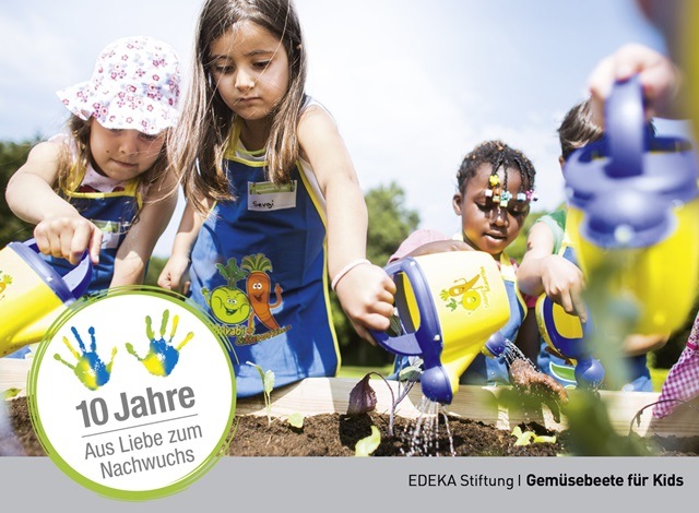 Mehrere Kinder wässern ein Gemüsebeet im Rahmen des Nachhaltigkeitsprojekts "Aus Liebe zum Nachwuchs".