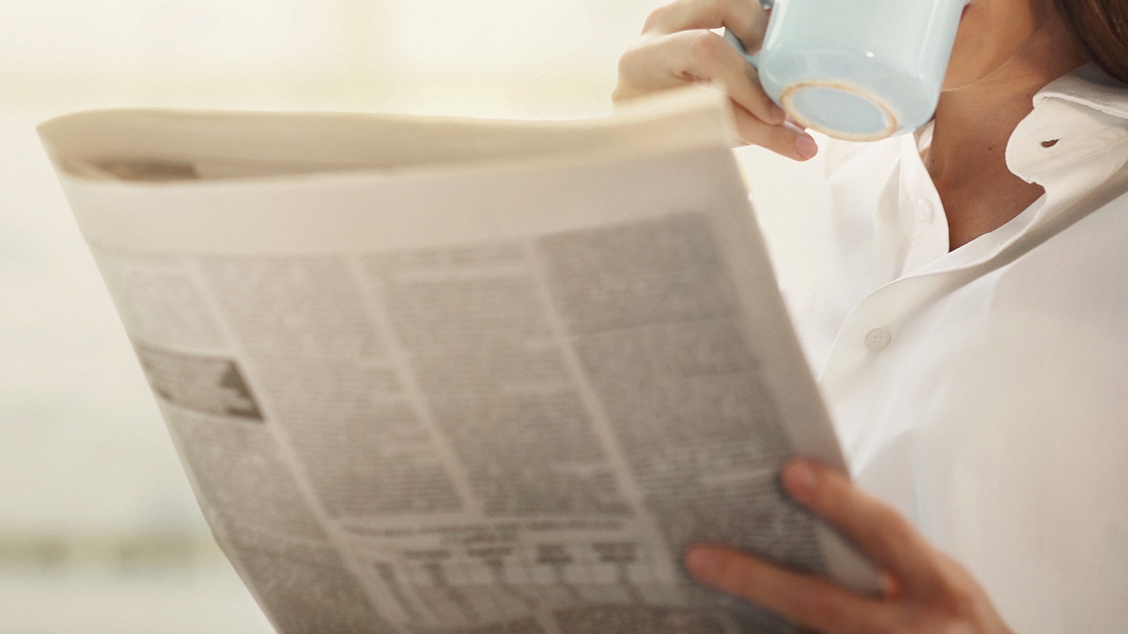 Person hält Zeitung in der Hand