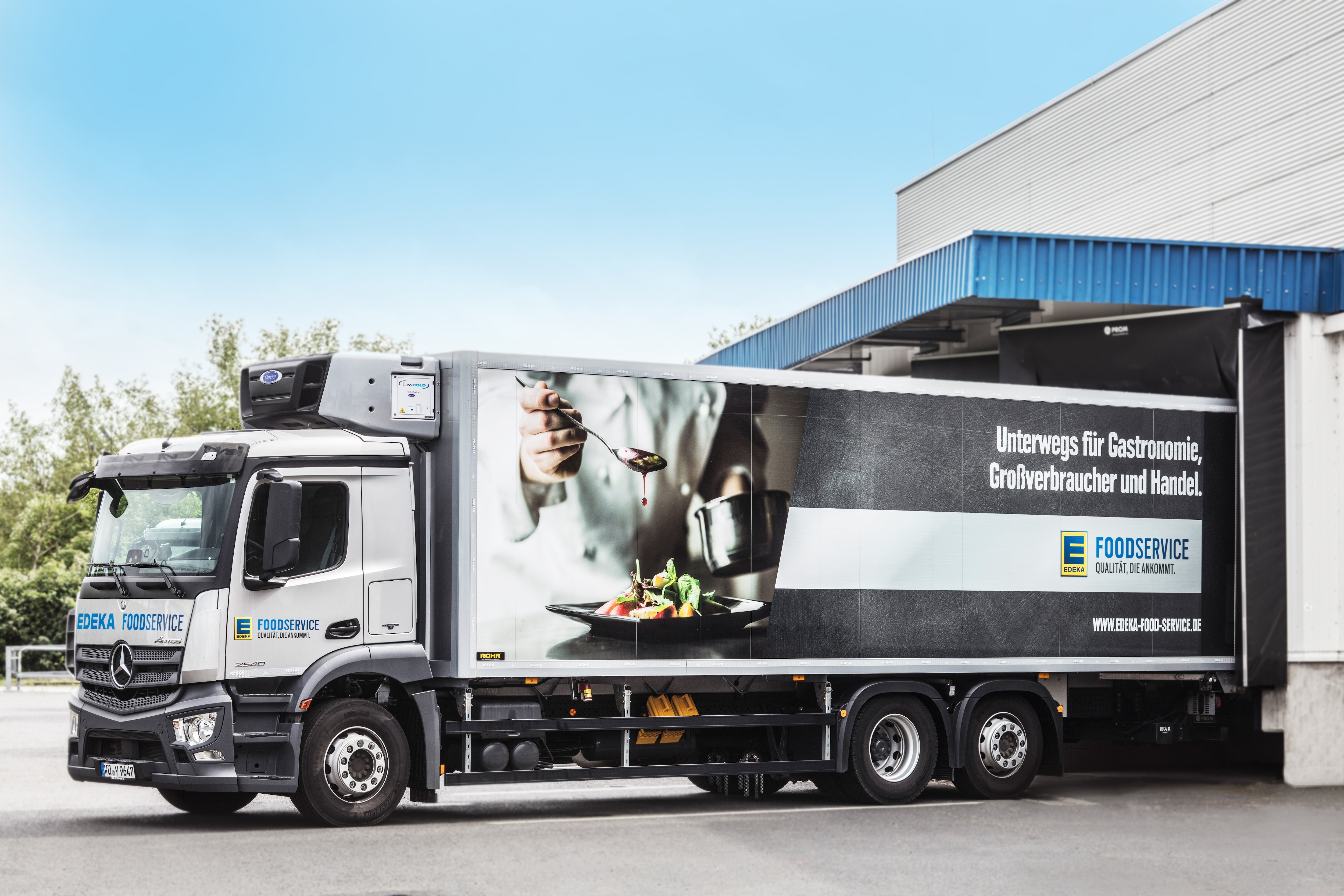 Ein weißer LKW verlässt eine Anlieferstelle. Auf dem Auflieger steht EDEKA Foodservice.