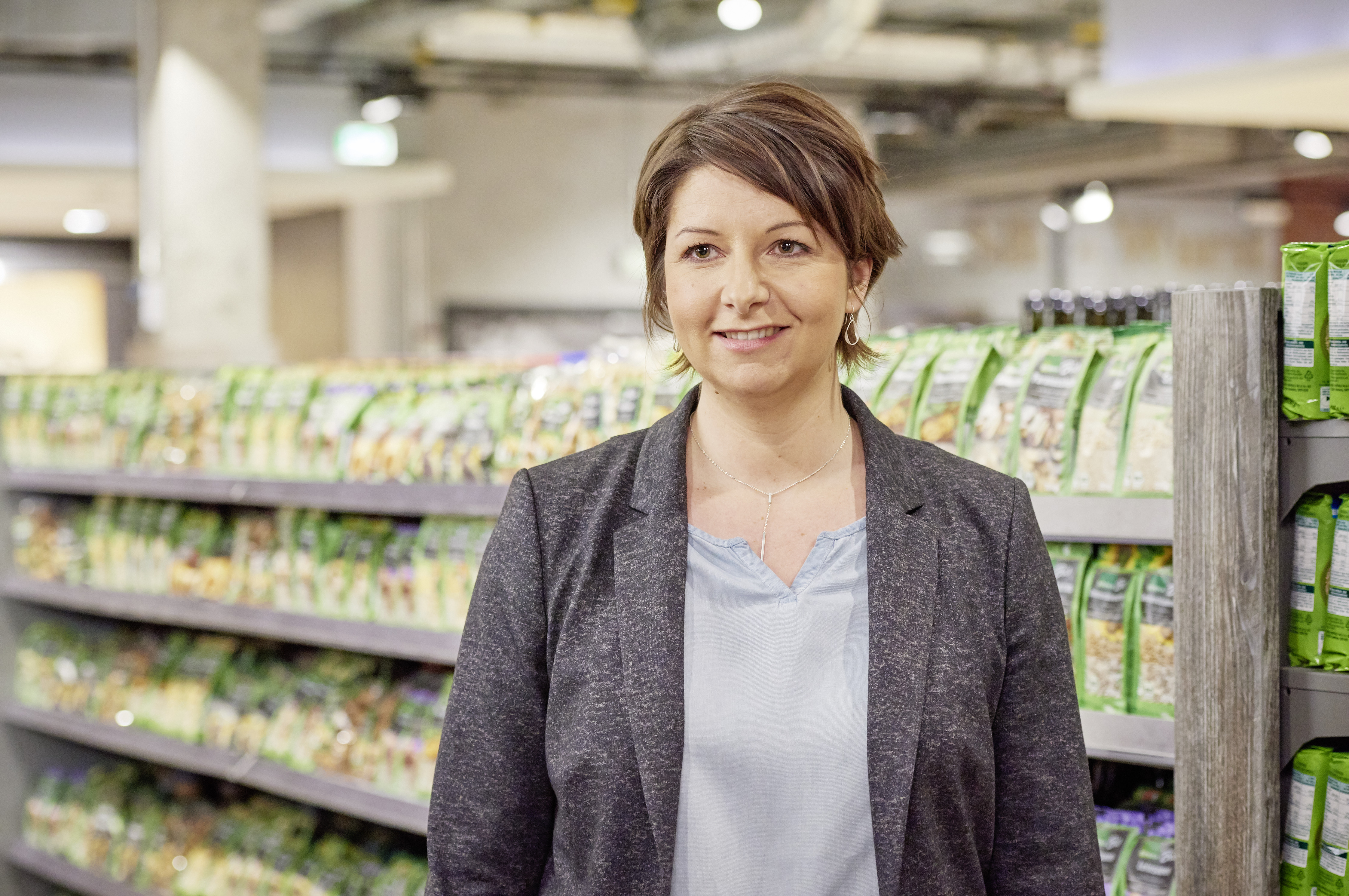 EDEKA-Kauffrau Nina Schulz steht in seinem Markt und blickt in die Kamera.