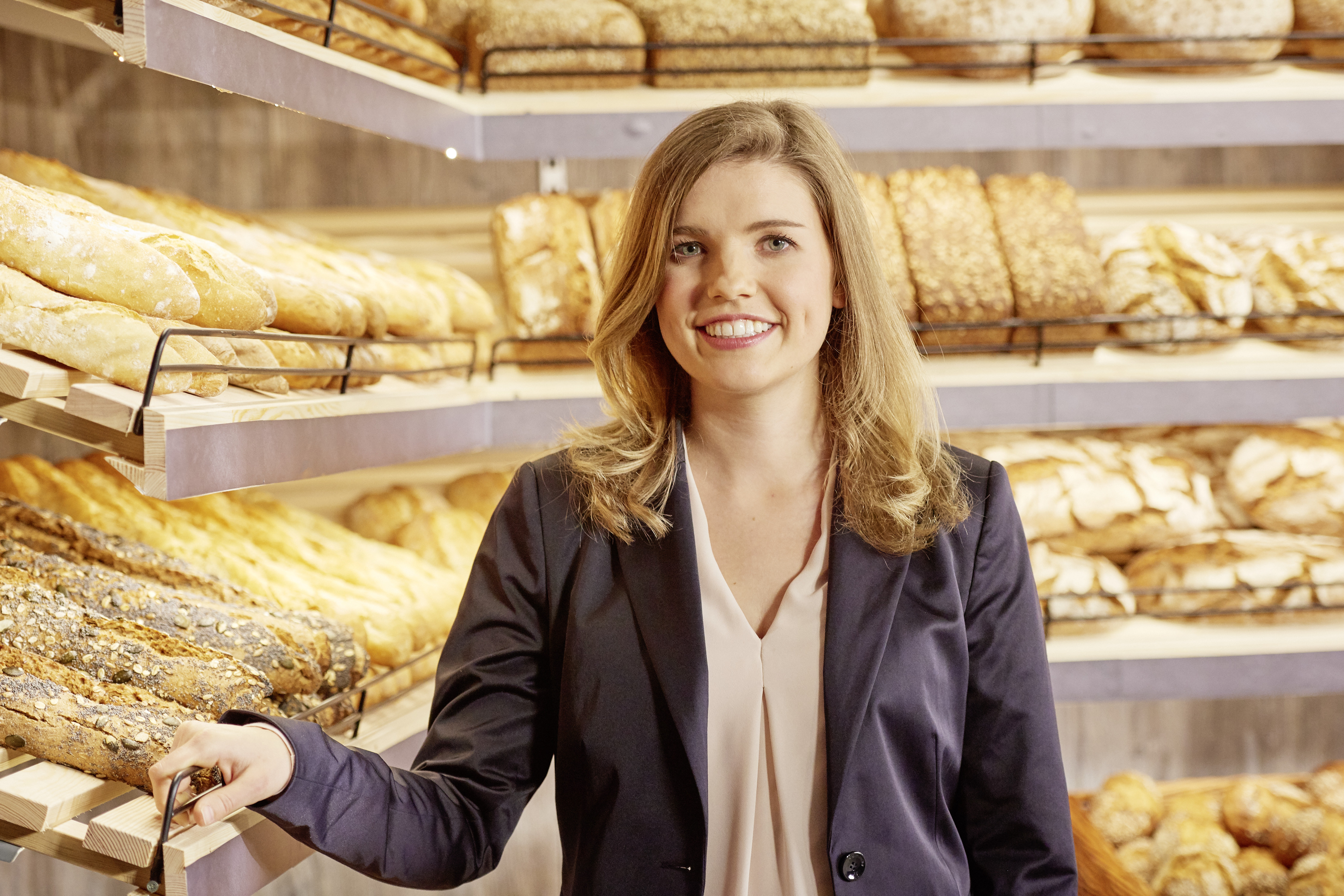EDEKA-Kauffrau Susanne Krämer-Kuhnle steht vor einem Regal mit Backwaren.