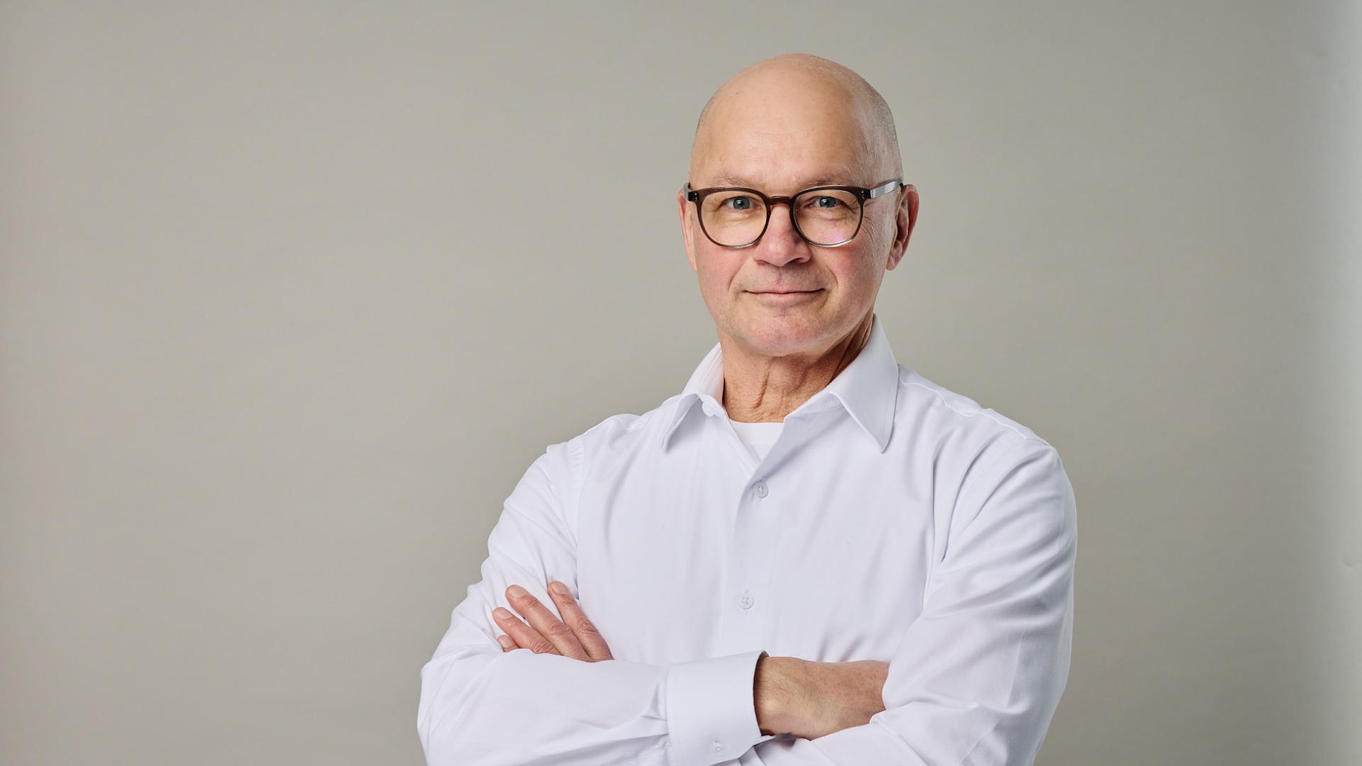 Norbert Fußer im Protrait vor grauem Hintergrund guckt professionell in die Kamera