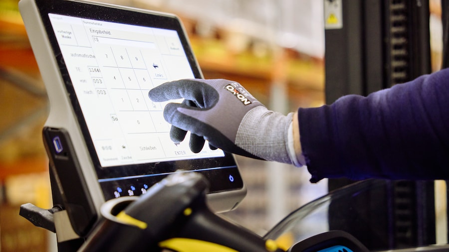 Person mit Handschuh bedient ein Touchscreen-Gerät.