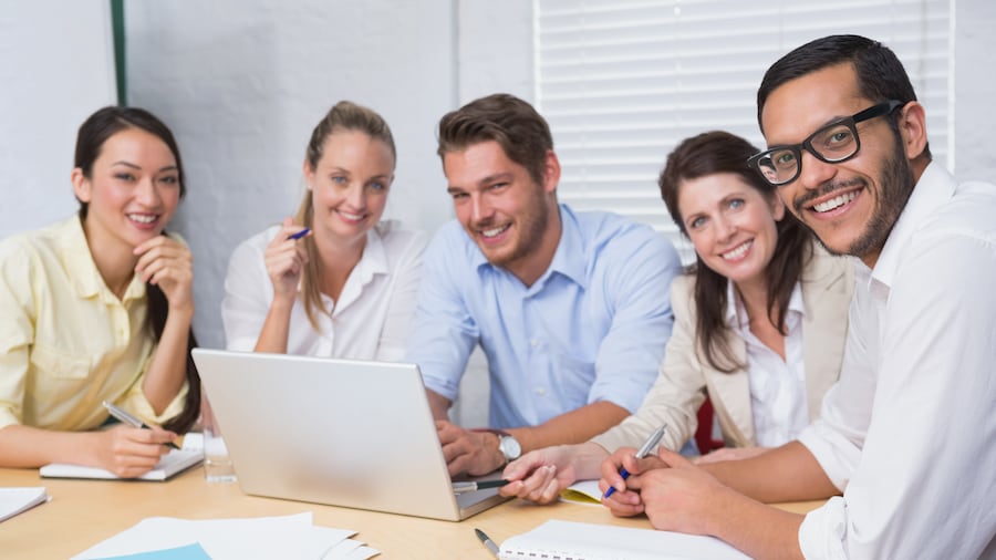 Gruppe von 5 Personen sitzt gemeinsam am Laptop.