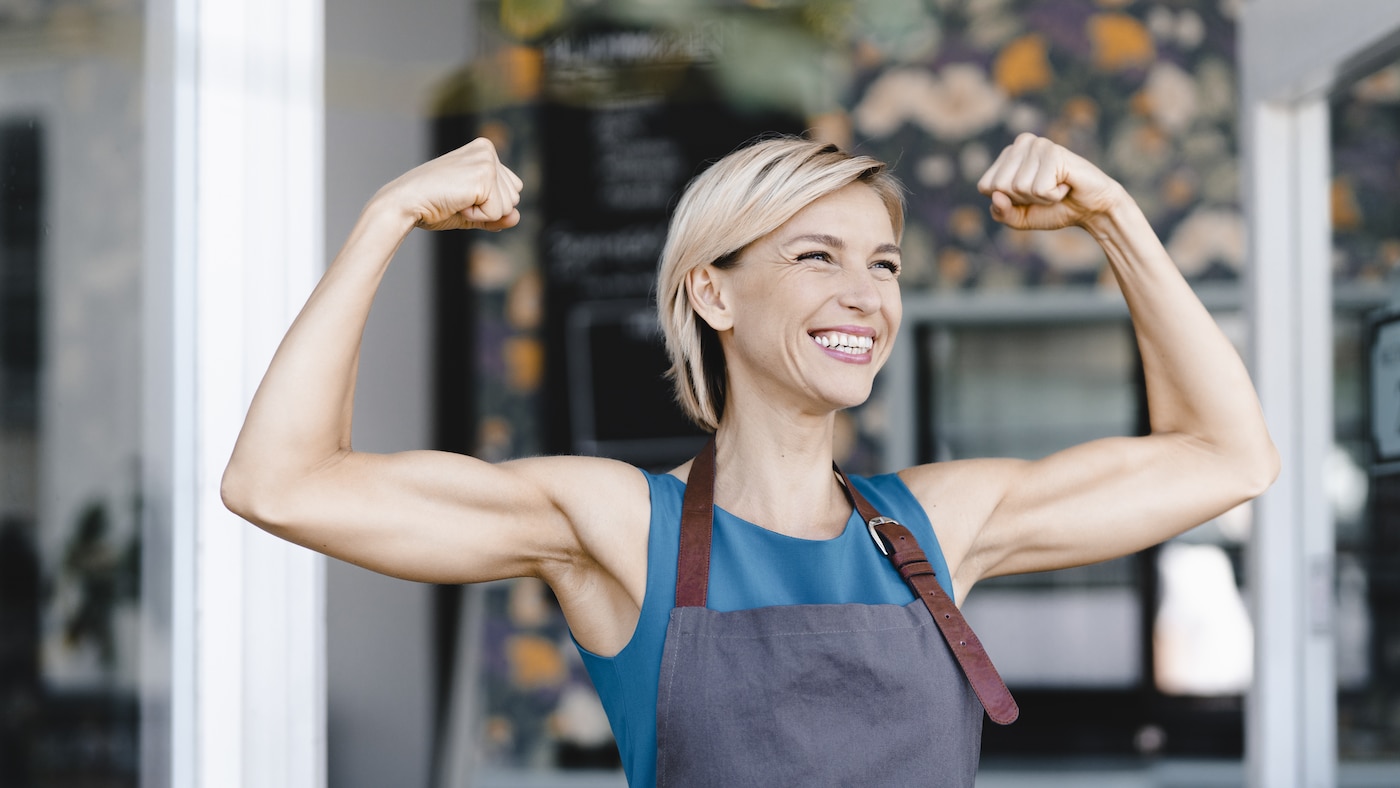 Eine Frau reckt beide Fäuste in einer Siegespose nach oben.