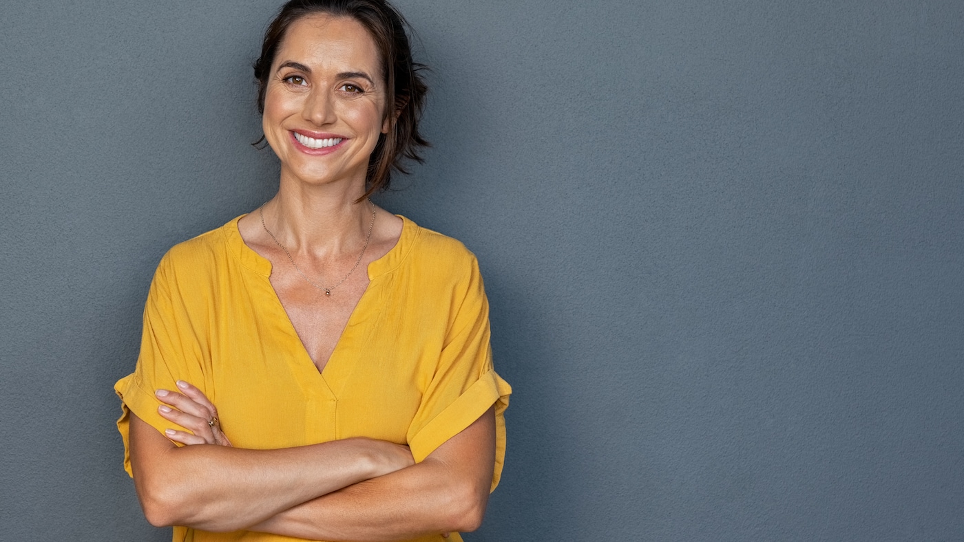 Frau im gelben Shirt lächelt in die Kamera
