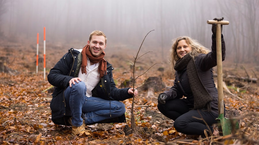 EDEKA Minden-Hannover Azubi-Baumpflanzaktion 2024 - 2 Helfende knien und lächeln freundlich in die Kamera