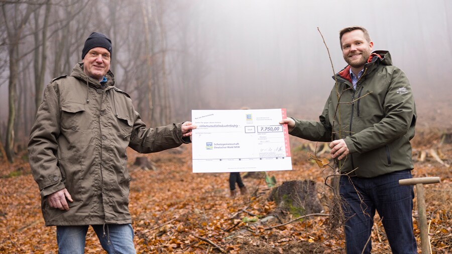 EDEKA Minden-Hannover Azubi-Baumpflanzaktion 2024 - 2 Männer halten Scheck in den Händen