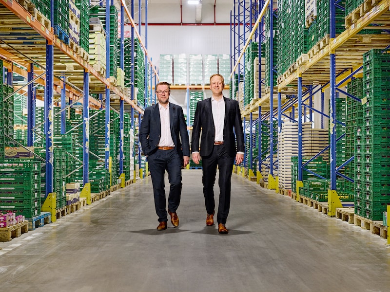 EDEKA Nord-Geschäftsführer Stefan Giese (links) und Frank Breuer (rechts) gehen durch das Frischdienstlager