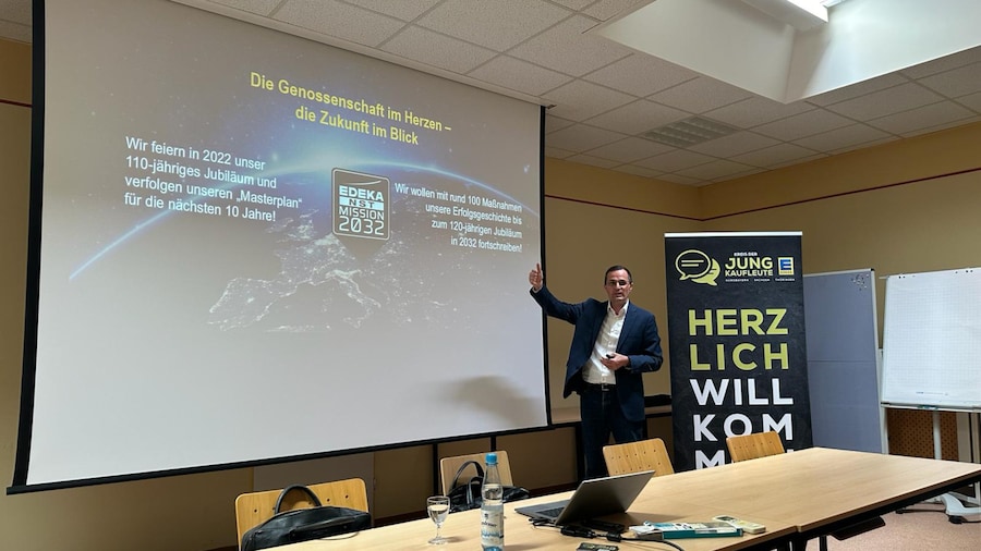 Hr. Kohrmann steht vor Leinwand