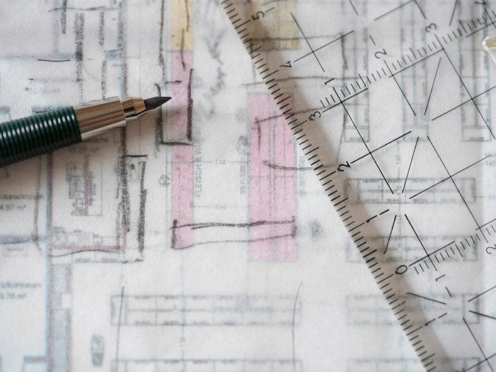 Grundriss eines EDEKA-Marktes mit Regalen. Darüber eine transparentes Papier auf dem mit Bleistift Änderungen gezeichnet sind