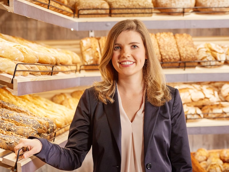 EDEKA-Kauffrau Susanne Krämer-Kuhnle steht vor einem Regal mit Backwaren.