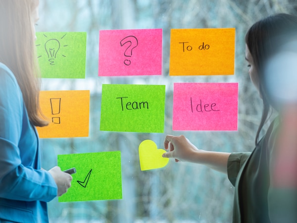 Teilnehmerinnen eines Workshops kleben Post-Its