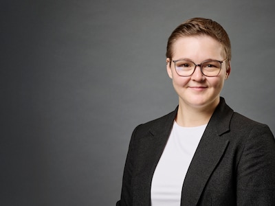 Theresa Hartenstein im Portrait vor grauem Hintergrund