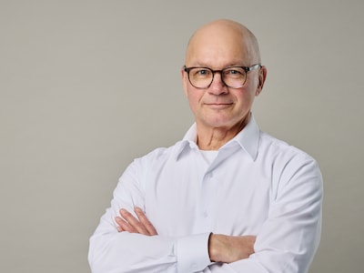 Norbert Fußer im Protrait vor grauem Hintergrund guckt professionell in die Kamera