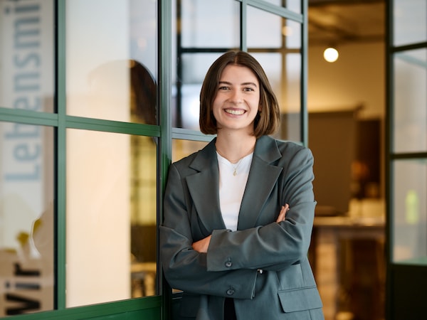 Lea Kramer lächelt mit verschränkten Armen in die Kamera