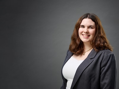 Lina Böhling lächelt vor grauem Hintergrund in die Kamera