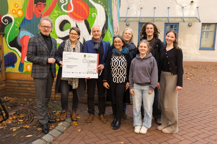 Die Beteiligten der Spendenübergabe halten den symbolischen Spendenscheck in den Händen.