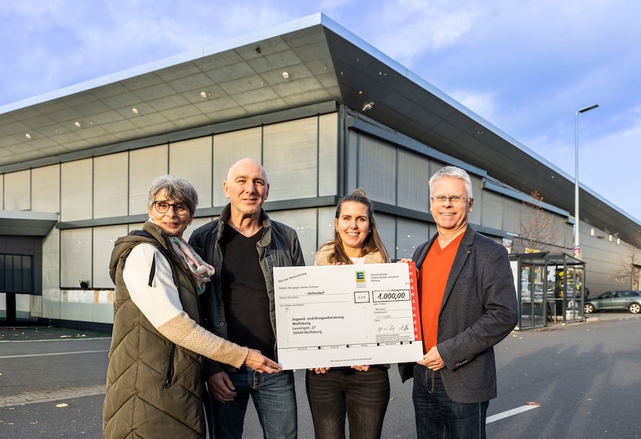 Die vier Beteiligten der Spendenübergabe stehen mit dem Spendenscheck vor dem EDEKA Center Wolfsburg.