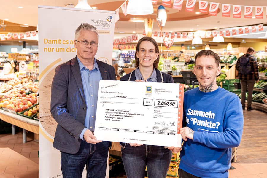 Die drei Beteiligten halten im EDEKA-Markt den Spendenscheck in der Händen.