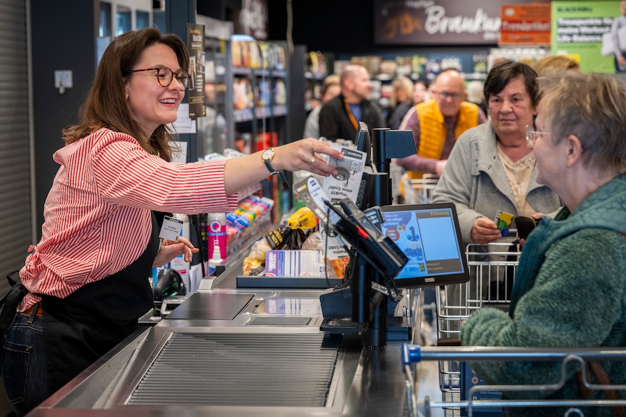 Die CDU-Abgeordnete Anna Aeikens steht hinter der Kasse und überreicht einer Kundin ihren Beleg.