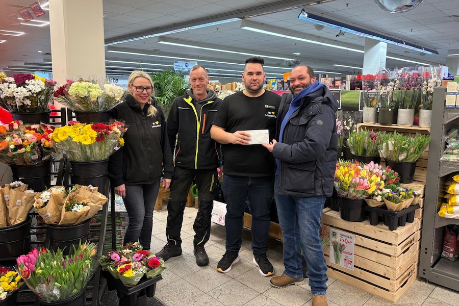 Die vier Beteiligten bei der Spendenübergabe in der Blumenabteilung des Markts.
