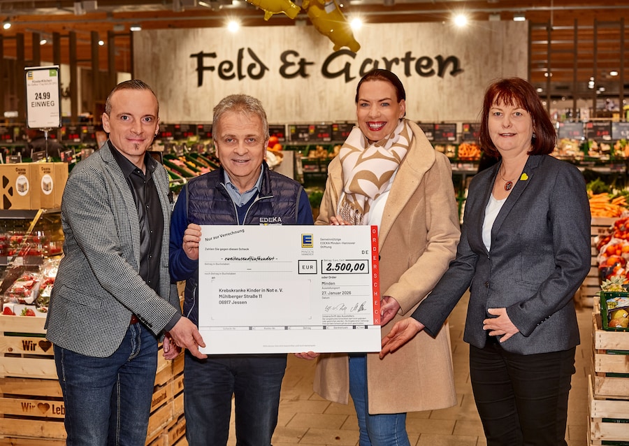 Der Spendenscheck wird in der Gemüseabteilung des Marktes übergeben.