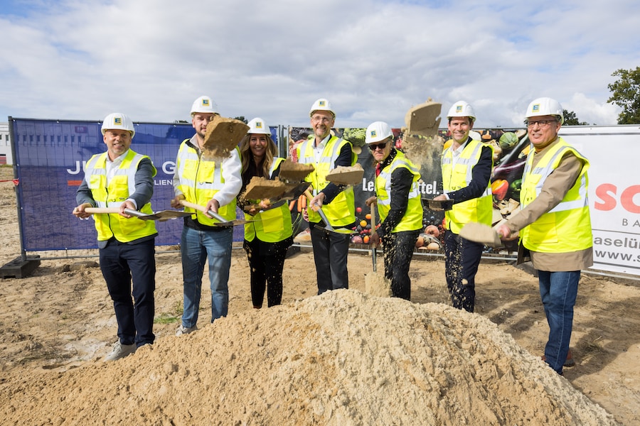Auf dem Areal der ehemaligen Süßwarenfabrik tätigen sieben Personen den ersten Spatenstich für das EDEKA Center in Bremen.