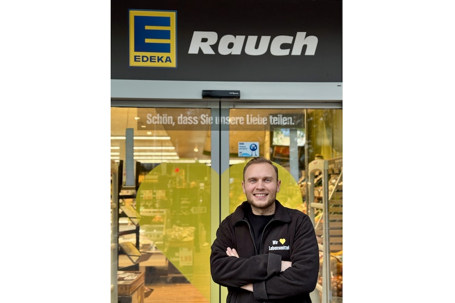 Der selbstständige Kaufmann Wilhelm Rauch steht vor dem Eingang seines EDEKA-Marktes.