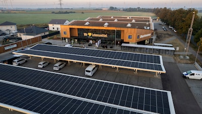 Der Zukunftsmarkt EDEKA Dorfmann in Nauen zeigt sich mit einer Holzfassade und Photovoltaik-Carports auf dem Parkplatz.