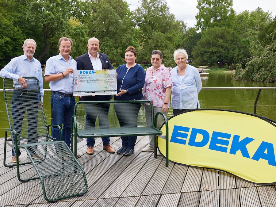 3 Männer und 3 Frauen stehen mit einem symbolischen Scheck vor einem See im Zoo Karlsruhe