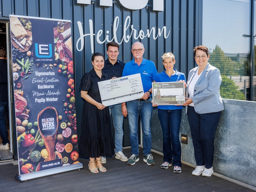 Fünf Personen mit Scheck vor dem umgebauten Trafohaus