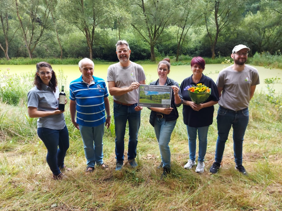 Sechs Personen mit Scheck vor Biotop