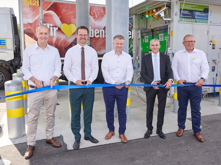 5 Männer stehen mit Scheren in der Hand vor einem Absperrband.