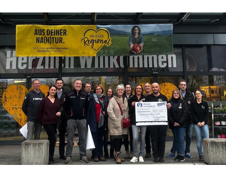 Mehrere Personen mit Scheck vor Markt