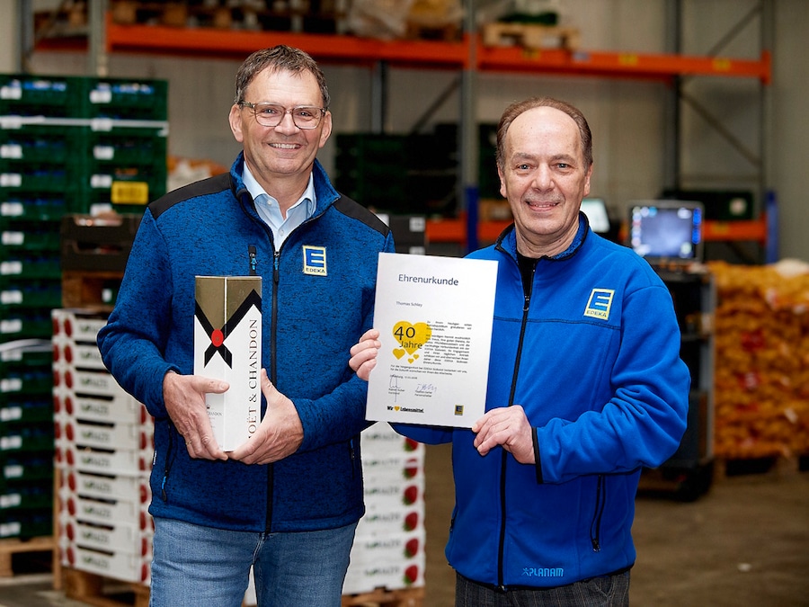 Zwei männliche Personen mit Urkunde