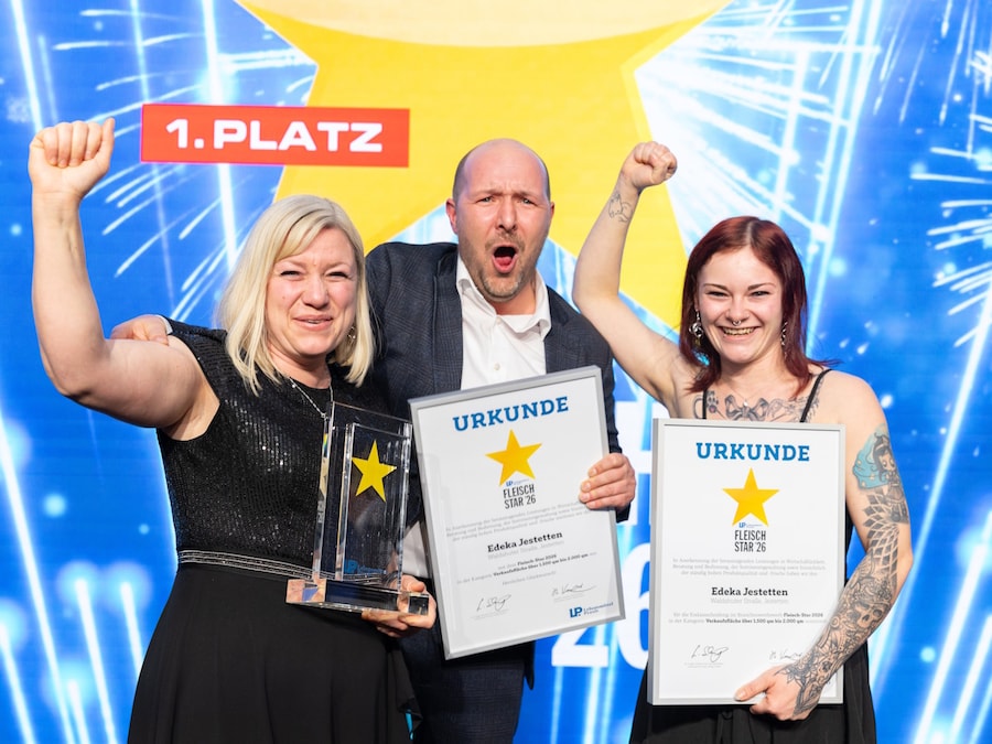 Drei Personen in Siegerpose mit Urkunden