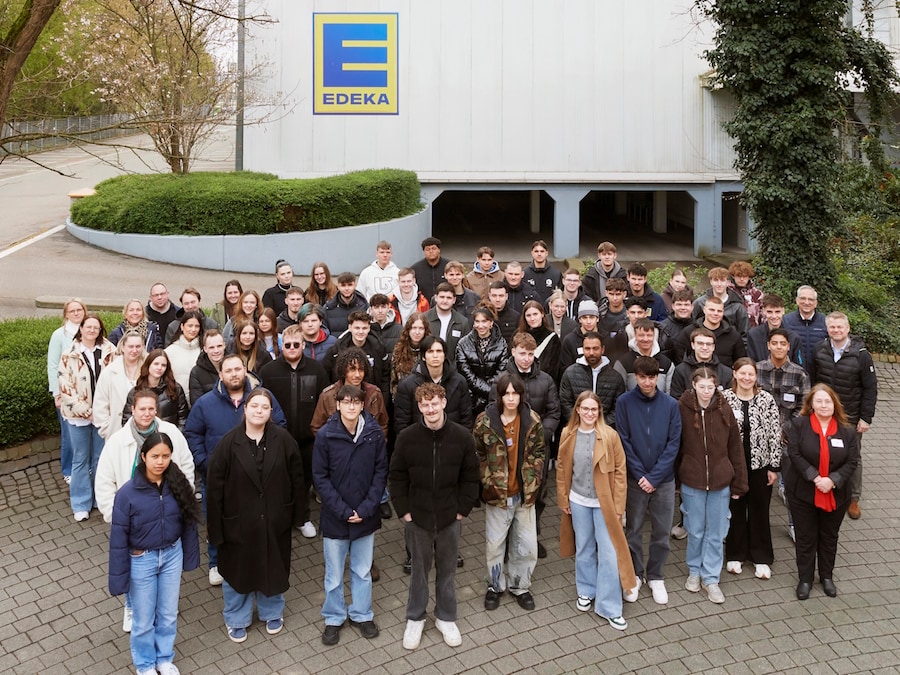Eine große Gruppe junger Menschen steht vor der EDEKA Zentrale in Offenburg.
